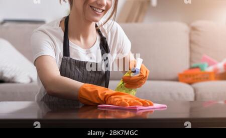 Professionelle Hausmädchen. Nahaufnahme Von Young Woman Reinigungstisch Aus Staub Stockfoto