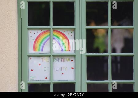 Ein selbstgemachtes Regenbogengemälde in einem Hausfenster in Großbritannien während der Pandemie von Covid-19 2020, Regenbögen in Fenstern, symbolisierte zu dieser Zeit Einheit in Hoffnung Stockfoto