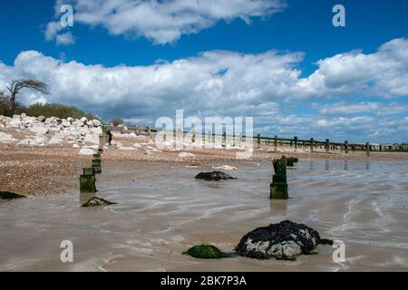 Schöne Aussicht bei Ebbe des Climping Beach an der Südküste Englands, die alten hölzernen Meeresverteidigungen sinken in den Sand. Stockfoto