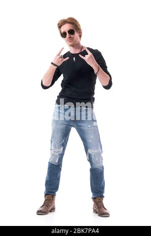 Rock and Roll Musiker in schwarzem Hemd zeigt Hard Rock Hand Zeichen Geste an der Kamera. Ganzkörper isoliert auf weißem Hintergrund. Stockfoto