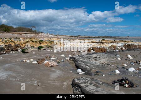 Dramatischer felsiger Strand bei Ebbe am Climping Beach in West Sussex England, an einem wunderschönen Frühlingstag. Stockfoto