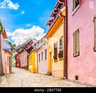 Sighisoara, Mures County, Transylvania, Romania: Alte mittelalterliche Kopfsteinpflasterstraße mit bunten Häusern im Zentrum der mittelalterlichen Festung Sighisoara. Stockfoto