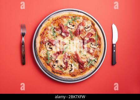 Hausgemachte Pizza mit Prosciutto crudo, Rucola, Mozzarella und Champignons. Flach lag mit einer Schinkenpizza fertig zu essen. Prosciutto und Rucola Pizza top vi Stockfoto