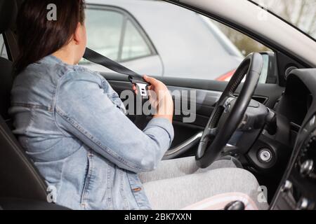 Fahrerfrau, die den Sicherheitsgurt im Auto befestigt, gegen Autounfall, Sicherheitskonzept, sicherer Transport Stockfoto