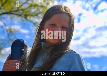 Portrait nettes kleines Mädchen auf dem Spielplatz an warmen und sonnigen Tag im Freien. Aktive Sommerfreizeitgestaltung für Kinder. Stockfoto