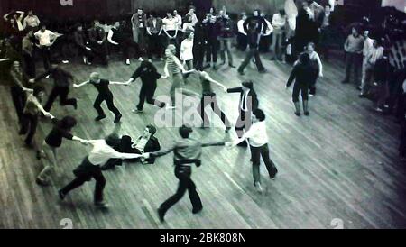 Männer tanzen im Kreis und halten sich an einer Spendenaktion im Camden Centre, London, England, Großbritannien, um Geld für die Gay Pride Week 1979 zu sammeln. London Gay Pride in diesem Jahr hatte das Thema: "Tonewall 69 Gay Pride 79". Stockfoto