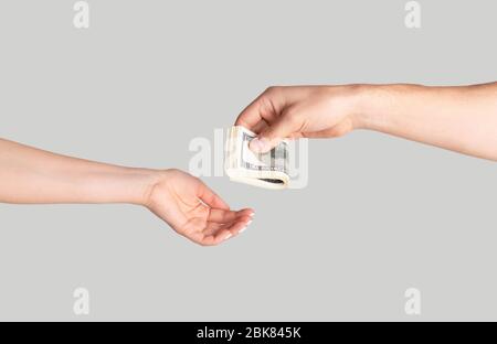 Unkenntlich Mann Geld an Frau auf hellem Hintergrund, Nahaufnahme der Hände Stockfoto