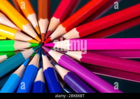 Viele verschiedene Buntstifte auf schwarzem Hintergrund reflektiert Stockfoto