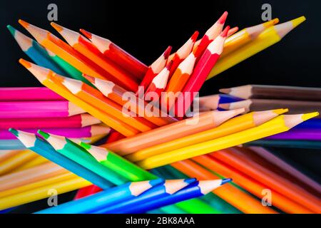 Viele verschiedene Buntstifte auf schwarzem Hintergrund reflektiert Stockfoto