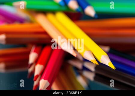 Viele verschiedene Buntstifte auf schwarzem Hintergrund reflektiert Stockfoto