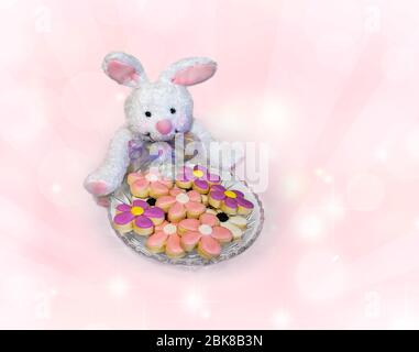 Kekse in Form von Blumen, in einer Kristallglas-Schüssel von einem weißen Hasen gehalten angezeigt. Stockfoto