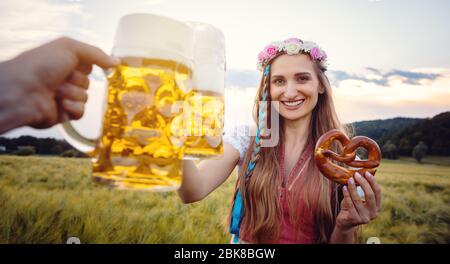 POV-Schuss von Paar in Bayern mit Bier toasten Stockfoto