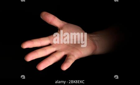 Menschliche männliche Handfläche eine Faust auf schwarzem Hintergrund isoliert. Nahaufnahme. Stockfoto