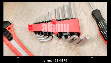 Worcker hält den sechseckigen Schlüssel in Handschuhen in der Hand. Nahaufnahme. Stockfoto