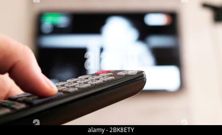 Männliche Hand hält Fernbedienung die Steuerung smit auf Smart tv. Nahaufnahme. Stockfoto