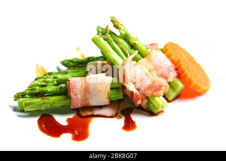 Gegrillter grüner Spargel mit Speck in weißem Hintergrund eingewickelt Stockfoto