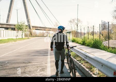 Radfahrer in Smog getönt Stadt in N95 Maske. Luftverschmutzung. Industriestadt. Mann in Maske aus Staub. Typ in Atemschutzmaske mit Filter pm 2.5. Thema Covid Stockfoto