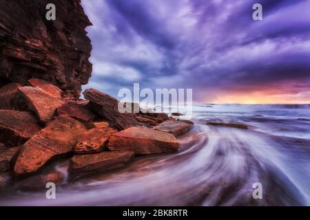 Wellen und Flut bei Sonnenaufgang an den Sydney Nonrther Stränden bei stürmischem Wetter. Stockfoto