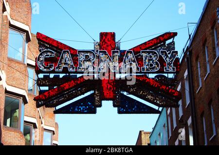 Bunte Stadt Anzeige Richtung Helles Zeichen von carnaby in großbritannien Stockfoto