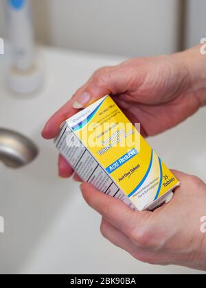 Frauen Hände halten Famotidin Box 20mg Tabletten. Das Medikament wird derzeit als Behandlung für COVID-19 einer Studie unterzogen. Stockfoto