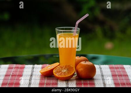 Orangensaft und frische Orangen auf Bokeh Hintergrund. Stockfoto