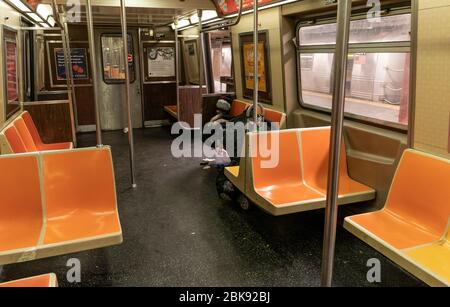 New York, NY - 2. Mai 2020: Obdachloser Mann sah, wie er in der U-Bahn-Station eines Zuges während der COVID-19-Pandemie in der 207 Straße in Inwood-Teil von Manhattan schlief Stockfoto