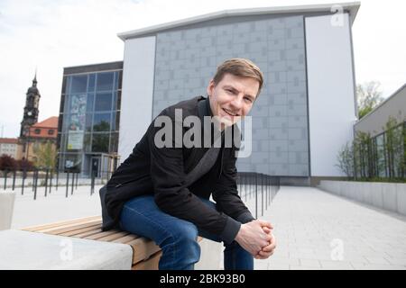 Dresden, Deutschland. April 2020. Martin Wolfram, ein Wasserspringer aus Deutschland, sitzt vor der geschlossenen Schwimm- und Tauchhalle. Der Europameister 2015 im Tower ist der Ansicht, dass die Verschiebung der Spiele in Tokio ein Geschenk der Zeit ist. Quelle: Sebastian Kahnert/dpa-Zentralbild/dpa/Alamy Live News Stockfoto