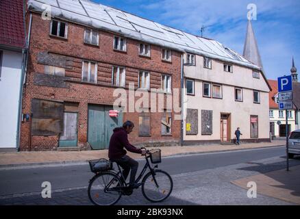 28. April 2020, Mecklenburg-Vorpommern, Bützow: Auch fünf Jahre nach dem Tornado haben die beiden leerstehenden Wohn- und Geschäftshäuser in der Langen Straße noch keine neuen Dächer. Fünf Jahre nach dem verheerenden Tornado wurden die meisten Gebäude in der kleinen Stadt restauriert. Der Tornado, der am Abend des 05.05.2015 durch Bützow fegte, hatte Schäden in Höhe von rund 40 Millionen Euro verursacht. Foto: Jens Büttner/dpa-Zentralbild/dpa Stockfoto