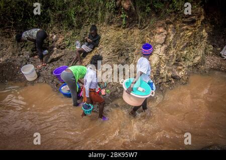 Nairobi, Kenia. April 2020. Junge Mädchen waschen ihre Kleidung an einem lokalen Fluss, ohne dabei soziale Distanz ohne Gesichtsmasken für ihre Sicherheit während der Corona-Virus-Pandemie zu mindern. Das tägliche Leben in Kibera Slums, das größte in Nairobi, wurde von der anhaltenden COVid19-Pandemie nicht stark beeinflusst, außer ein paar Aktivitäten, die durch die aufgrund der Pandemie verhängte Ausgangssperre begrenzt wurden. Quelle: SOPA Images Limited/Alamy Live News Stockfoto