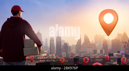 Liefermann hält Paketboxen auf Karte PIN Position. Schnelle und kostenlose Lieferung Transport. Online-Shopping und Express-Delivery-Konzept. Kopierbereich. Stockfoto