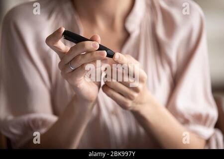 Nahaufnahme junge Frau Messung Glucose-Niveau, mit Lanzette Stift Stockfoto