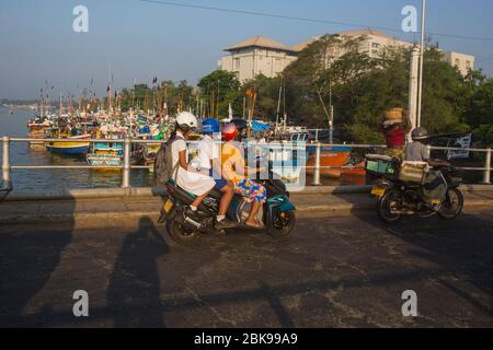 Sri Lanka Mutter und Schule gehen Kinder auf einem Roller in Negombo, Srilanka fahren. Stockfoto