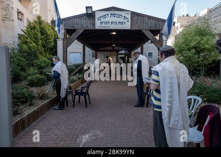 Jerusalem, Israel. Mai 2020. Jüdische Männer führen ihr Morgengebet außerhalb einer Synagoge unter Beachtung sozialer Distanzierungsvorschriften. Quelle: Nir Alon/Alamy Live News Stockfoto
