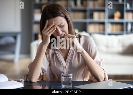 Ungesunde Frau, die unter Kopfschmerzen, Einnahme von Pille Stockfoto