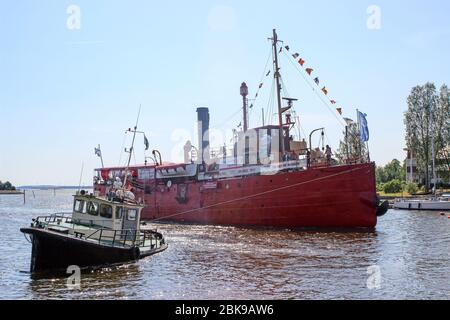 Schlepper Rautu manövriert S/S Hyöky - ehemaliges Lichtschiff Helsinki - zum Pier von Tervasaari in Hamina, Finnland Stockfoto