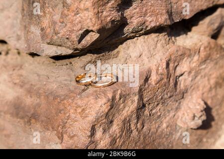 Zwei Eheringe an einer alten Steinmauer Stockfoto