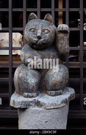 Geschnitzte hölzerne Glückspilz (maneki neko) Stockfoto