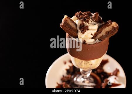 Schmackhafter Milchshake im Glas auf schwarzem Hintergrund Stockfoto