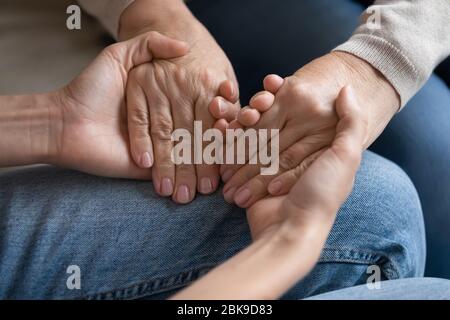 Junge Frau mit älteren Mutterhänden, Hilfe und Unterstützung Stockfoto
