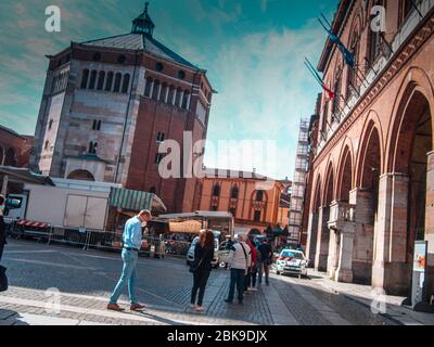 Cremona, Lombardei, Italien - 2. Mai 2020 - Polizeibeamter, der die Körpertemperatur kontrolliert und den Zugang zum Open-Air-Lebensmittelmarkt im Stadtzentrum kontrolliert Stockfoto