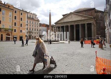 Rom - Italien, 2. Mai 2020: Eine Frau mit dem Einkaufswagen geht am Pantheon-Denkmal in Rom während der Sperrung des Covid-19-Pandemienotfalls in Rom, die auf Phase 2 wartet. Stockfoto