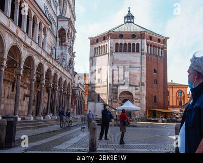 Cremona, Lombardei, Italien - 2. Mai 2020 - Polizeibeamter, der die Körpertemperatur kontrolliert und den Zugang zum Open-Air-Lebensmittelmarkt im Stadtzentrum kontrolliert Stockfoto