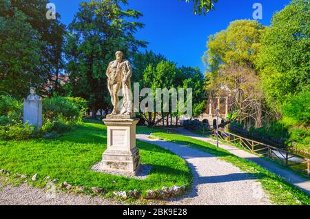 Vicenza, Italien, 12. September 2019: Farnese Hercules Ercole Farnese die alte Statue des Herkules in Salvi Gärten Park mit grünen Bäumen, Valmarana Lodge Gebäude, historisches Stadtzentrum, Venetien Region Stockfoto