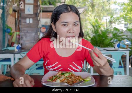 Thai Dame mit Bambus Essstäbchen zum Essen Pad thai Essen im Restaurant Stockfoto