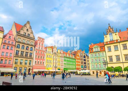 Breslau, Polen, 7. Mai 2019: Reihe von bunten traditionellen Gebäuden mit bunten Fassaden und Spaziergänger auf Kopfsteinpflaster Rynek Marktplatz in der Altstadt historischen Stadtzentrum Stockfoto