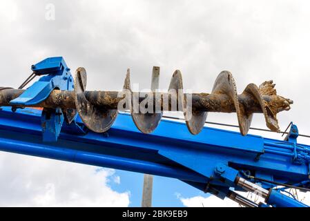 Traktorschlepper mit Schnecke für Bodenbohrungen bei der Montage von Pfählen während des Baus von Gebäuden und Strukturen Stockfoto