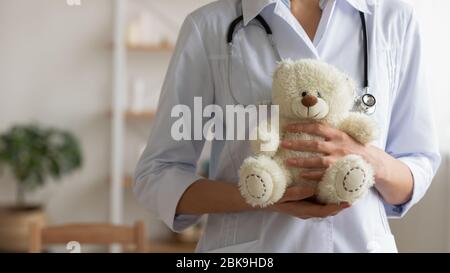 Kinderärztin, die den Teddybär in Händen hält, Nahaufnahme Stockfoto
