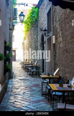 Straßencafé in einer engen Straße in der Altstadt von Kotor, Montenegro, August 2018 Stockfoto