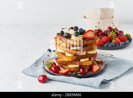 Französisches Toast mit Beeren und Banane, Brioche-Frühstück, weißer Hintergrund, Nahaufnahme Stockfoto