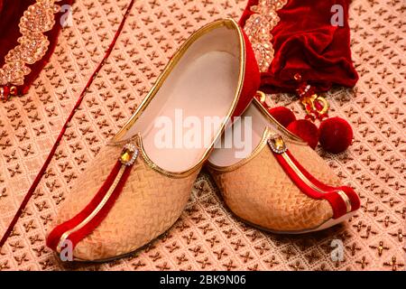 Erstaunliche hinduistische Trauung. Details der traditionellen indischen Hochzeitskleidung. Wunderschön dekorierte hindu Hochzeit Accessoires. indische Bräutigam Schuhe Stockfoto